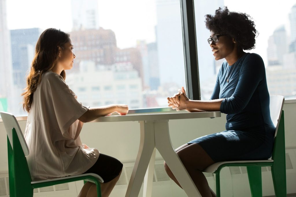 Two colleagues sitting across a table in conversation